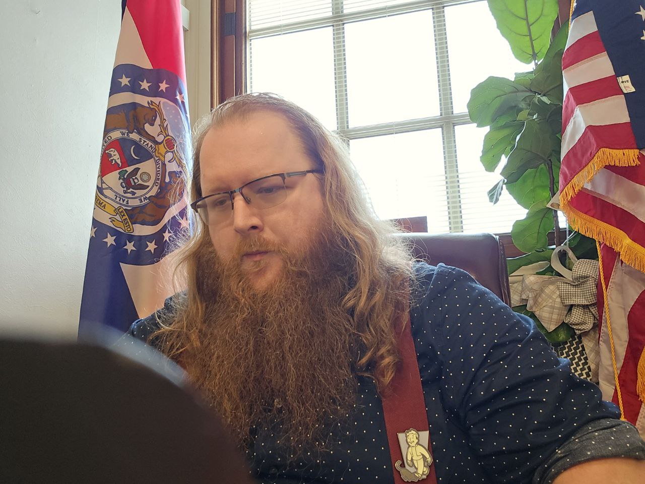 Clayton Harbison at desk with Missouri and U.S. flags